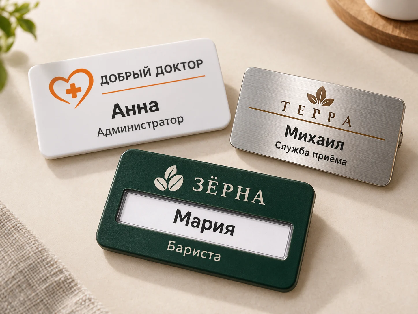Бейджи с разным оформлением: белый с именем администратора, серебристый для отеля и зелёный со сменным именем бариста